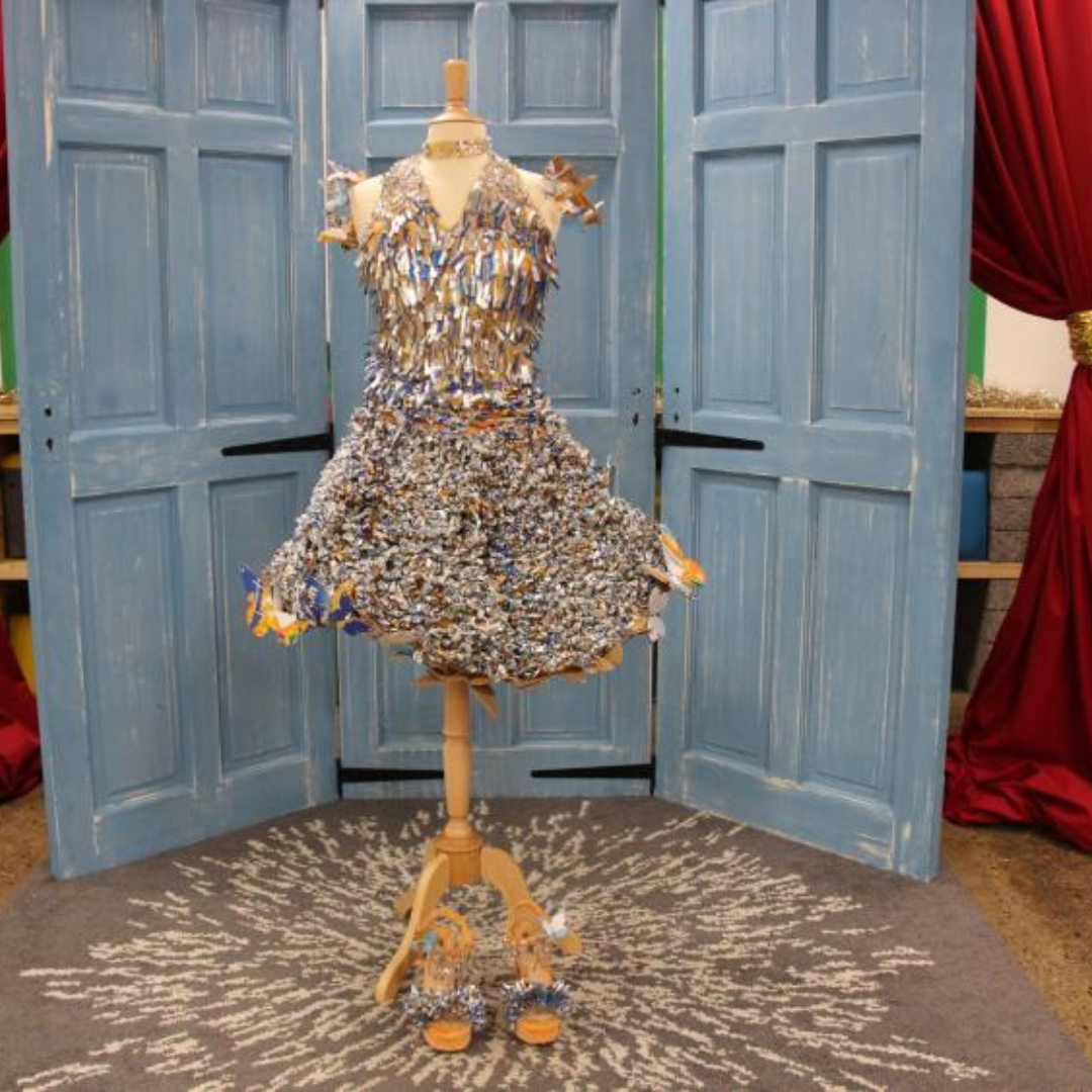 Relove Fashion 2021 Winner dress on mannequin, the dress is sparkly, textured, sleeveless and knee length